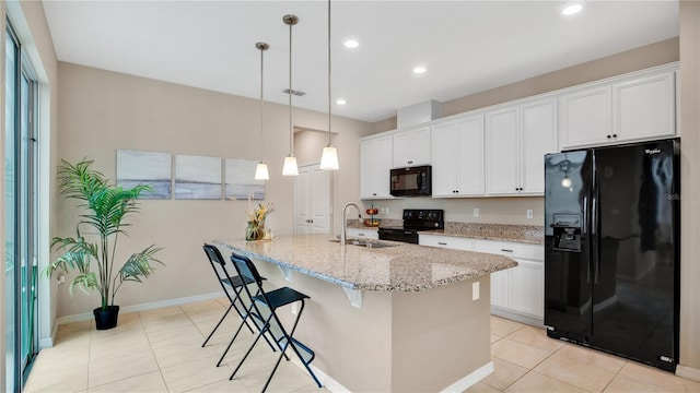 kitchen featuring sink, a center island with sink, white cabinets, and black appliances