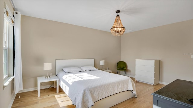 bedroom featuring a notable chandelier and light wood-type flooring