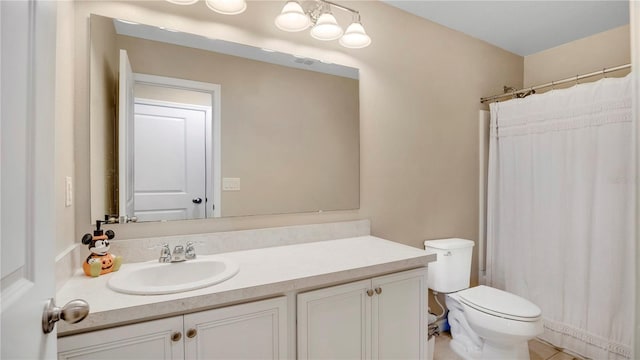 bathroom with vanity, curtained shower, and toilet