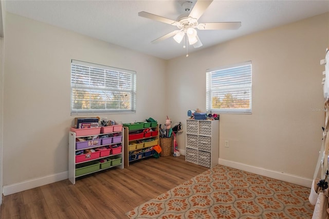 rec room featuring light wood-type flooring, plenty of natural light, and baseboards