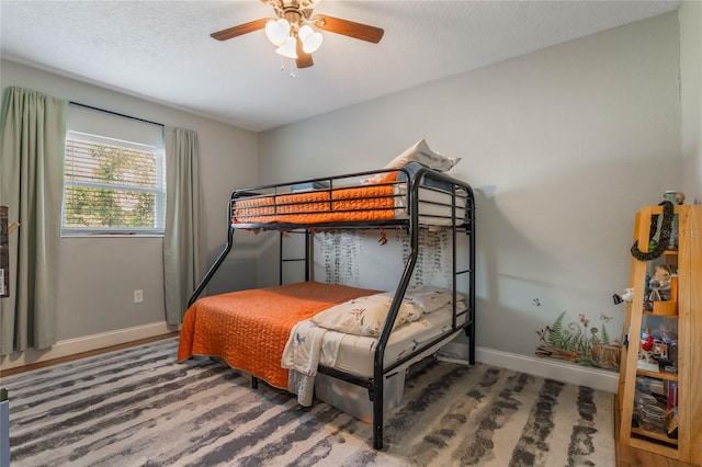 bedroom with ceiling fan, baseboards, and a textured ceiling