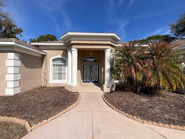 doorway to property featuring stucco siding