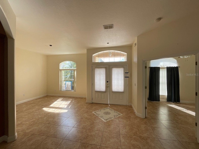 entrance foyer featuring a textured ceiling, visible vents, and baseboards