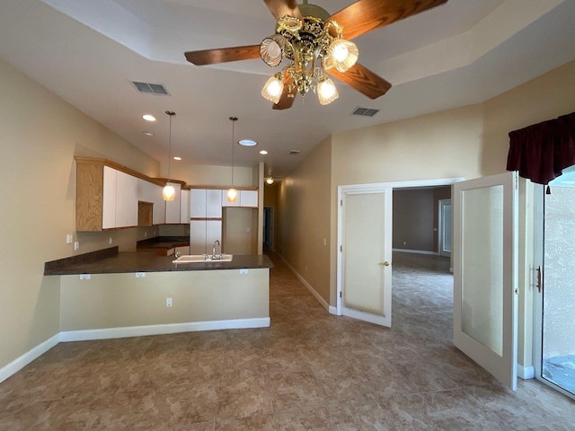 kitchen featuring a peninsula, visible vents, white cabinetry, dark countertops, and pendant lighting