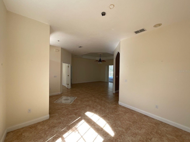 unfurnished room featuring visible vents, arched walkways, ceiling fan, and baseboards