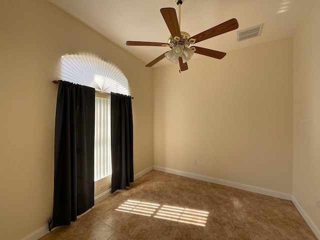 empty room featuring light tile patterned floors, baseboards, visible vents, and ceiling fan