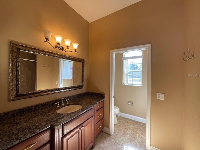 bathroom with baseboards, vanity, and toilet