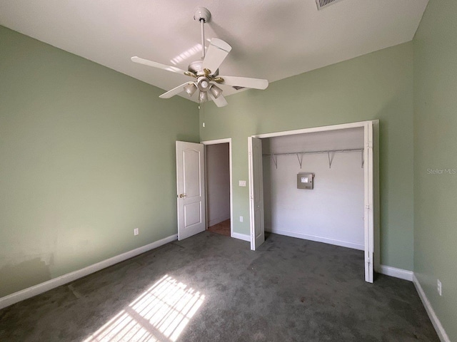 unfurnished bedroom with ceiling fan, a closet, and dark colored carpet