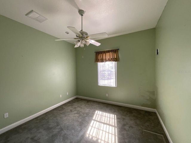 unfurnished room featuring ceiling fan and dark colored carpet