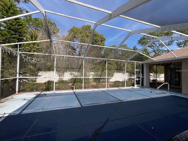 view of swimming pool featuring glass enclosure