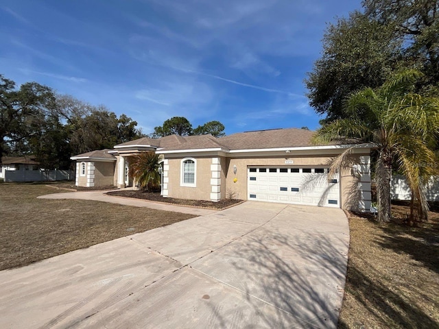 single story home featuring a garage, a front yard, driveway, and stucco siding