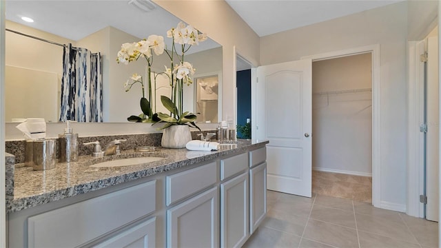 bathroom with tile patterned flooring, vanity, and an inviting chandelier