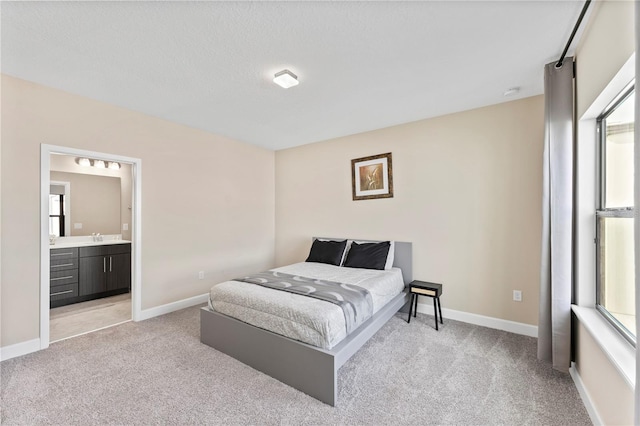 bedroom featuring ensuite bath and light carpet