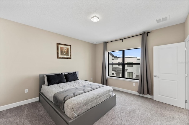 bedroom with carpet floors and a textured ceiling