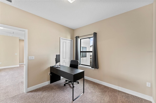 carpeted home office featuring a textured ceiling