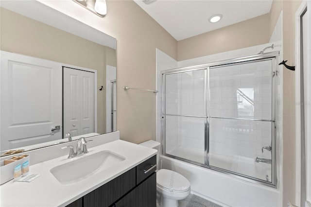 full bathroom featuring enclosed tub / shower combo, vanity, and toilet