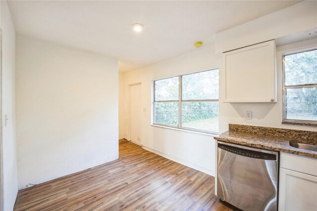 kitchen with white cabinetry, dishwasher, dark stone countertops, and light wood-type flooring