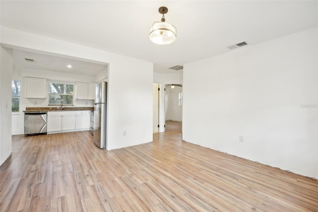 unfurnished living room with sink and light wood-type flooring