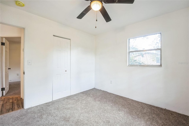 unfurnished bedroom featuring carpet, ceiling fan, and a closet