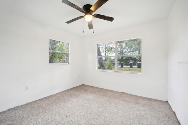 unfurnished room with ceiling fan and carpet