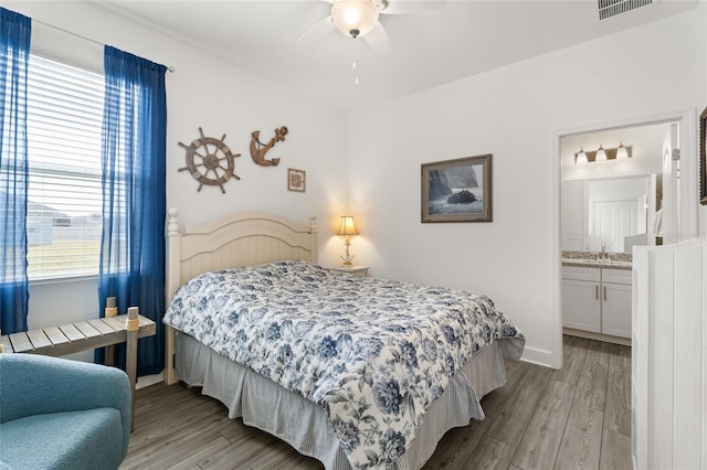 bedroom with sink, ensuite bathroom, ceiling fan, and light wood-type flooring