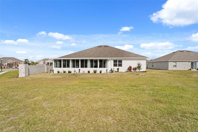 back of property with a lawn and a sunroom