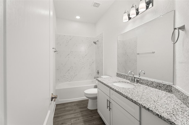 full bathroom featuring vanity, wood finished floors, visible vents, shower / tub combination, and toilet