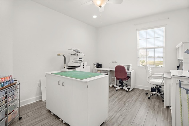 office featuring ceiling fan, light wood-type flooring, and baseboards