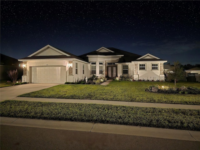 view of front of property with concrete driveway, an attached garage, a lawn, and stucco siding