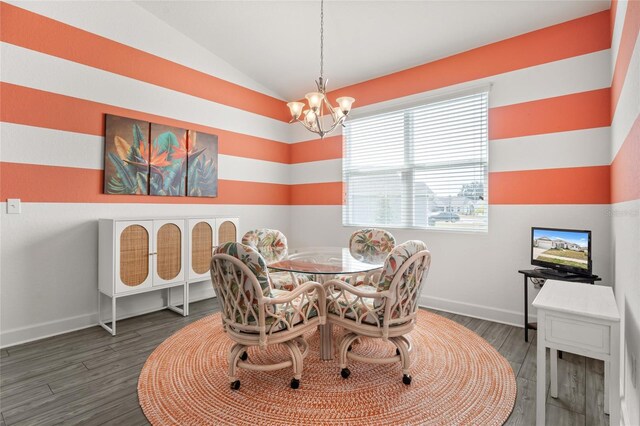 dining room featuring baseboards, wood finished floors, a notable chandelier, and vaulted ceiling