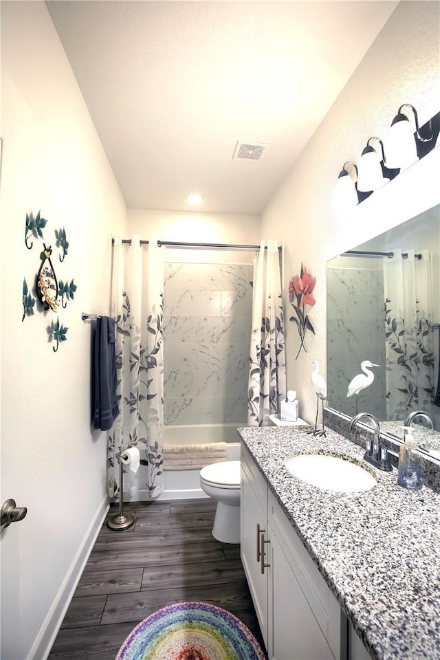 full bathroom with vanity, visible vents, toilet, wood finished floors, and shower / tub combo