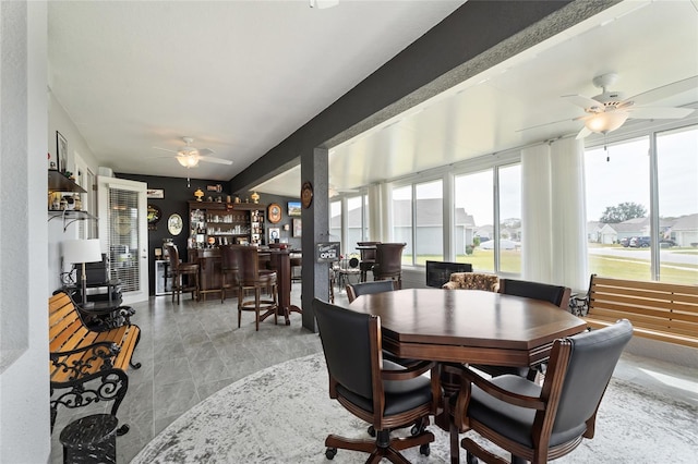 dining room with a bar, a healthy amount of sunlight, and ceiling fan