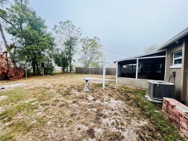 view of yard with a sunroom and central AC unit