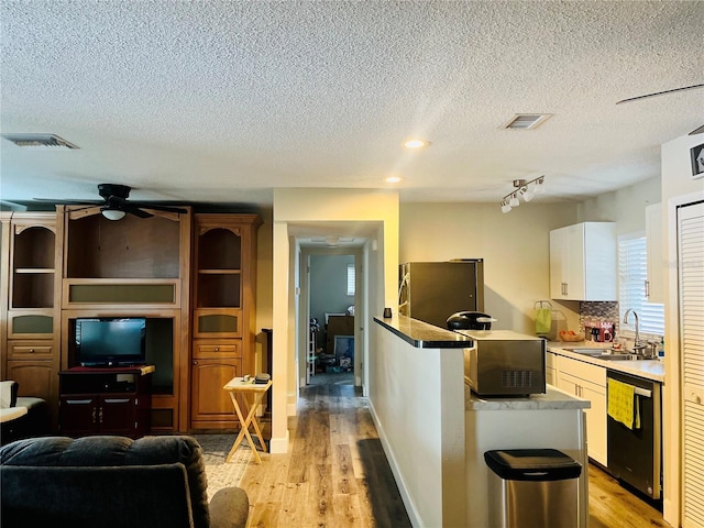 kitchen featuring sink, light hardwood / wood-style flooring, stainless steel refrigerator, dishwasher, and white cabinets