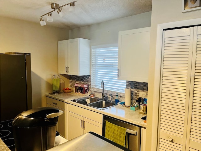 kitchen with stainless steel appliances, white cabinetry, sink, and decorative backsplash