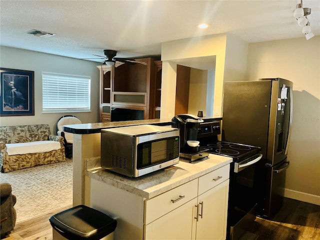 kitchen featuring range with electric cooktop, ceiling fan, white cabinetry, and light hardwood / wood-style flooring