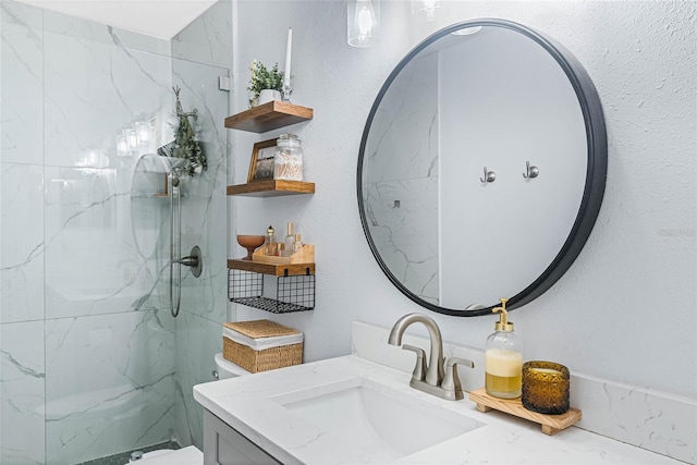 bathroom with tiled shower, vanity, and toilet