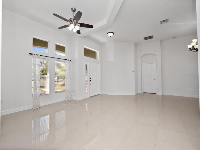 tiled empty room with ceiling fan with notable chandelier