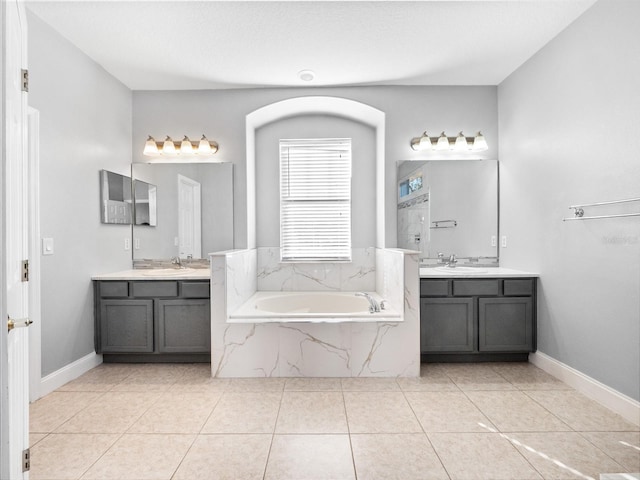 bathroom featuring vanity, tile patterned floors, and tiled bath