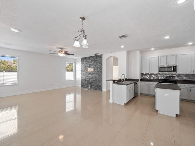 kitchen with pendant lighting, sink, a wealth of natural light, and appliances with stainless steel finishes