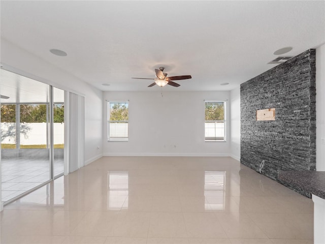 tiled spare room with a wealth of natural light and ceiling fan