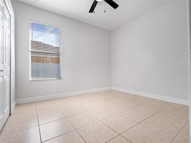 empty room with ceiling fan and light tile patterned floors