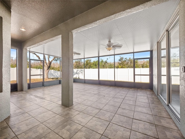 unfurnished sunroom with ceiling fan and a healthy amount of sunlight