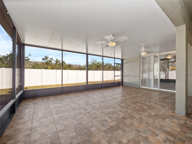 unfurnished sunroom featuring ceiling fan