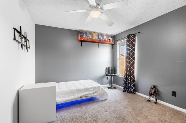 carpeted bedroom with ceiling fan and a textured ceiling