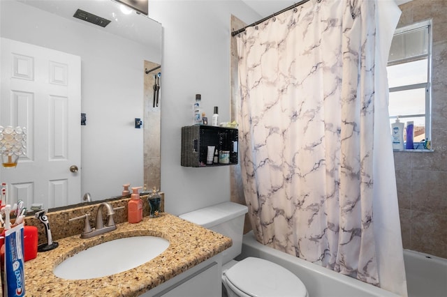 full bathroom featuring shower / tub combo with curtain, vanity, and toilet