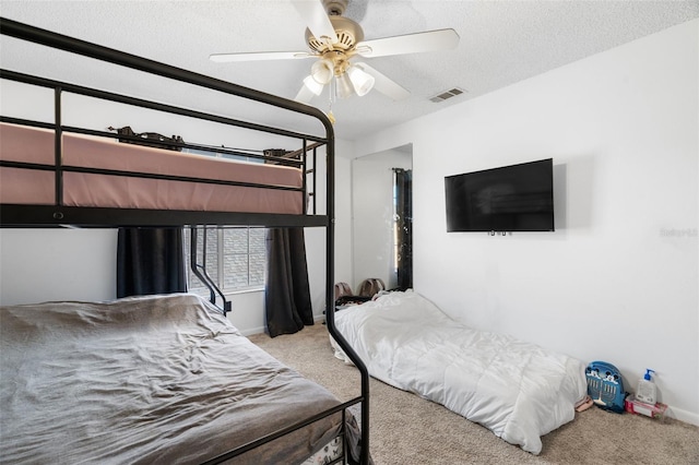 bedroom featuring ceiling fan, light colored carpet, and a textured ceiling