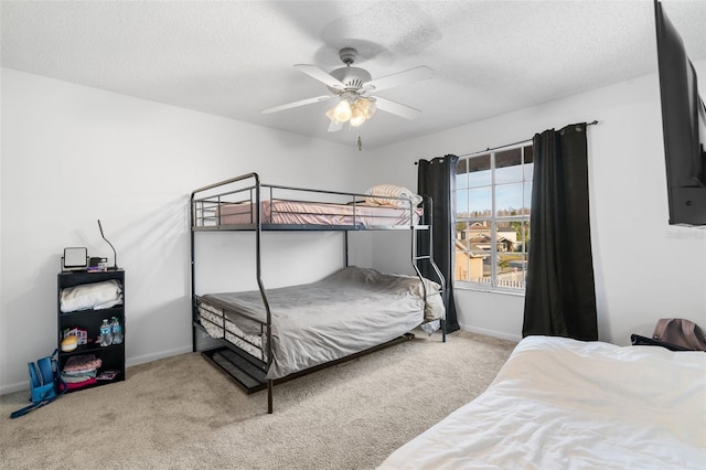 carpeted bedroom featuring ceiling fan and a textured ceiling