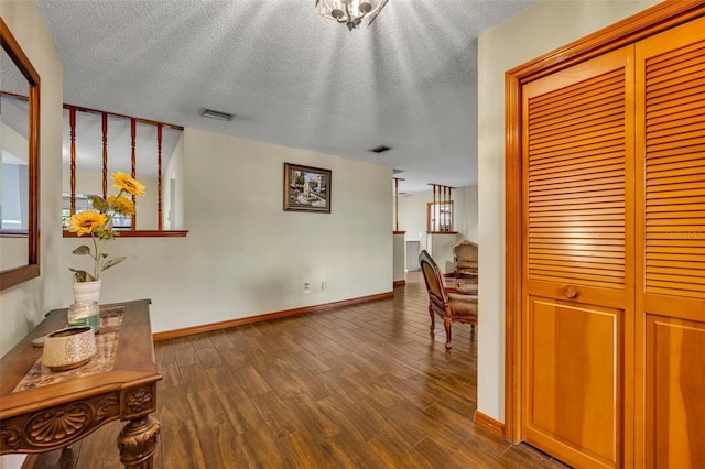 hallway with hardwood / wood-style flooring and a textured ceiling