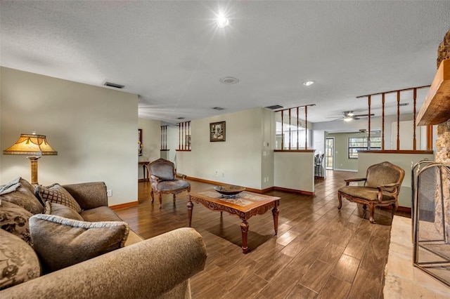 living room with ceiling fan, hardwood / wood-style floors, and a textured ceiling